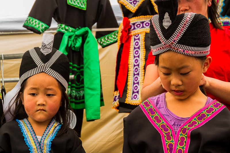 Zuag Vang  helps her oldest daughter Rose Vang to wear the traditional Hmong hat. On the left is her second daughter, Cherry. 