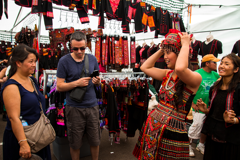 Melodie Vang, 24, tries the traditional Hmong clothing and waits for her mother Vaj Kub and her fiance Nicolas Raho's review. Vang and her family came from France to visit their family and also joined the July 4th Festival.